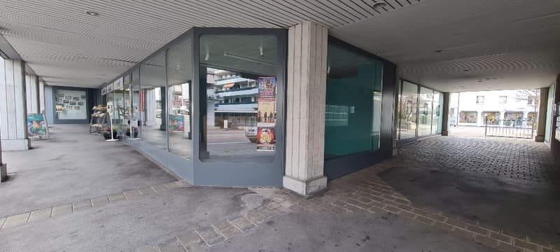 Commercial space with glass walls, brick pavement, and a wide entrance