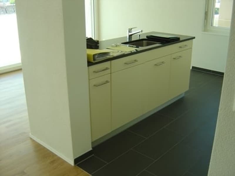 countertop, sink, cabinets, tile floor, small room