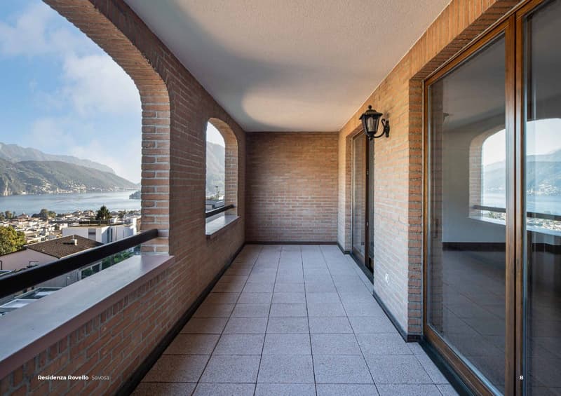 tiled floor, brick walls, glass balcony doors, balcony with railings, view of the lake and mountains