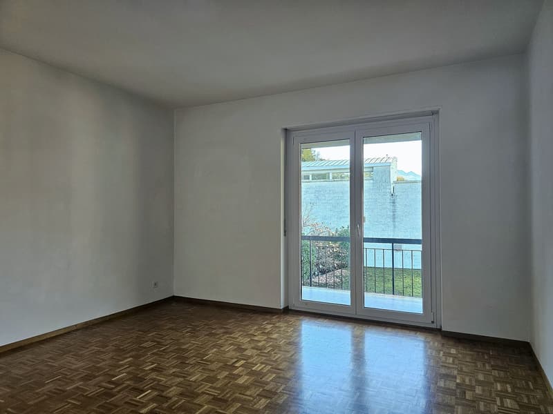 wooden floors, white walls, glass sliding doors, balcony with metal railing