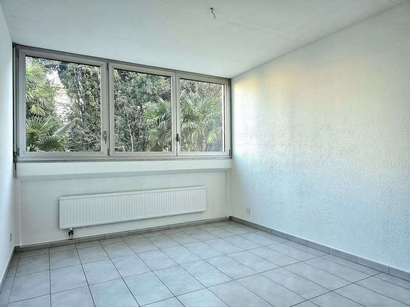 Empty room with windows, tiled floor, wall radiator