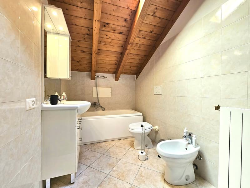 a bathroom with bathtub, toilet, sink, bidet, wooden ceiling, white tile floor, white wall