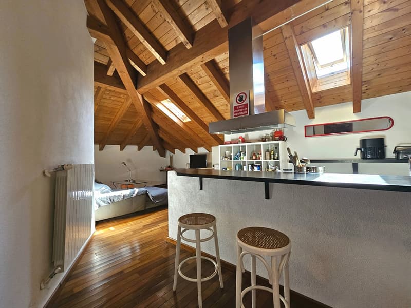 wooden ceiling, white walls, wooden floor, kitchen island, stools, bed, desk, radiator