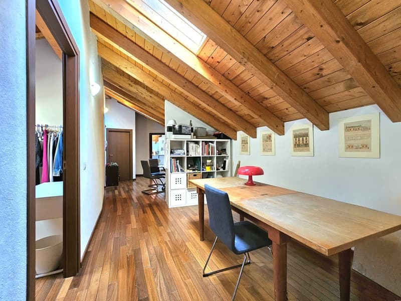 large wooden table, bookshelves, red lamp, blue chair, wooden floor, wooden ceiling