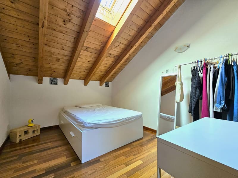 skylight, wooden floor, white storage bed, yellow lamp, wooden bench, closet, mirror, closet with clothes