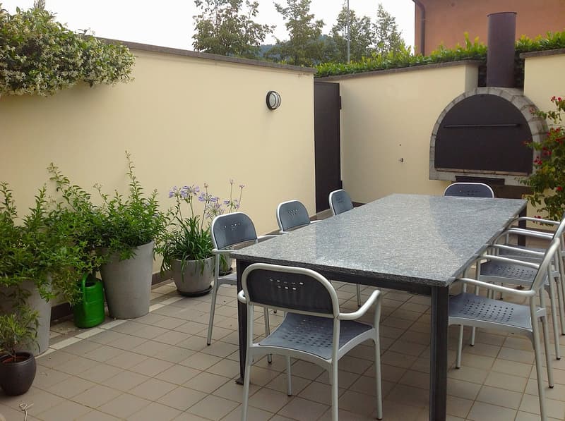 table with 6 chairs, plants, outdoor oven, paved floor, good view