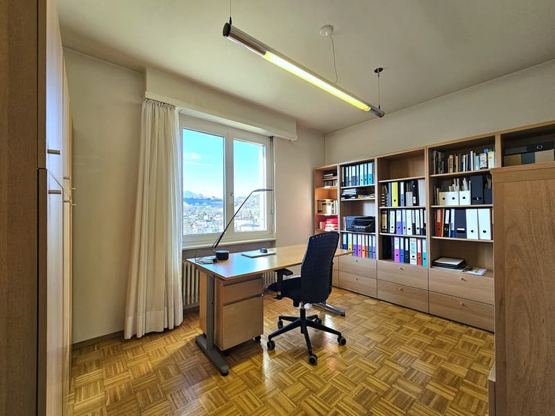 wooden desk, black chair, lamp, bookcase, window with curtain, parquet floor