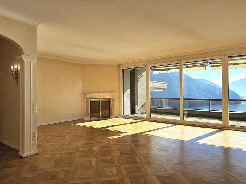 large room, wooden parquet floor, fireplace, sliding glass doors to balcony, ocean view