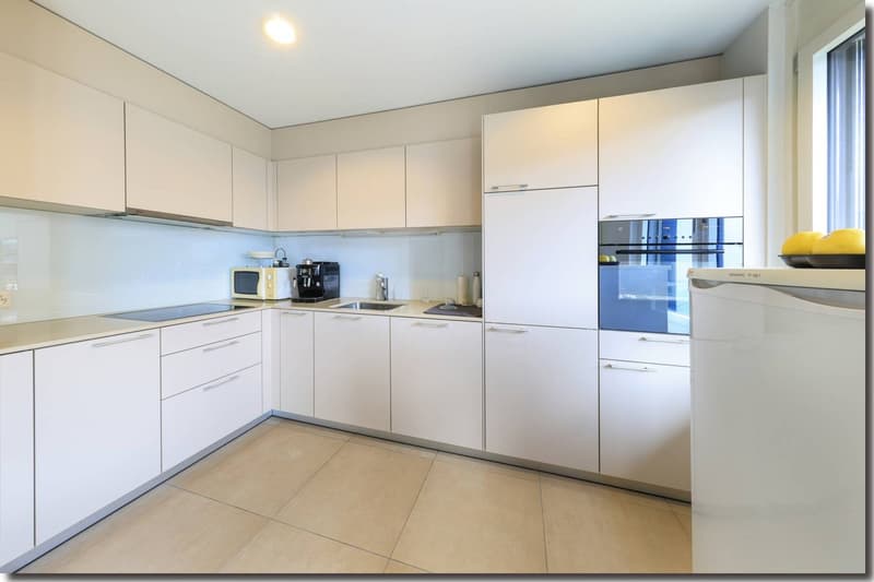 modern kitchen with white cabinetry, tiled flooring, central island, and stainless steel appliances