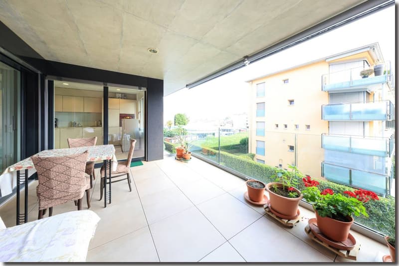 Table with chairs, flowers, pillows, view of the building