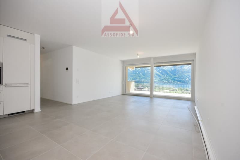 large room with a tiled floor, a balcony, and a beautiful view of the sea and mountains