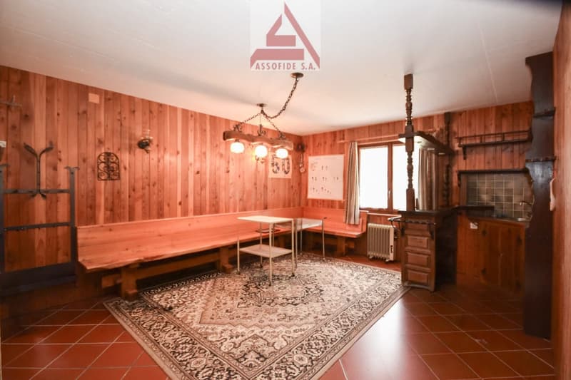 wooden walls, radiator, large window with curtains, wooden benches, small desk, chandelier, carpet