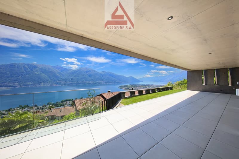 a balcony with panoramic view of the mountains and lake