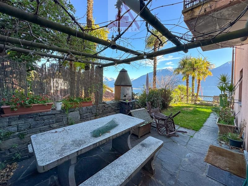outdoor dining table with a bench, stone wall, plants and mountain view