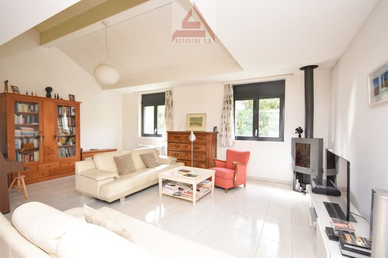 white couch, wooden cabinet, TV, red chair, coffee table, fireplace