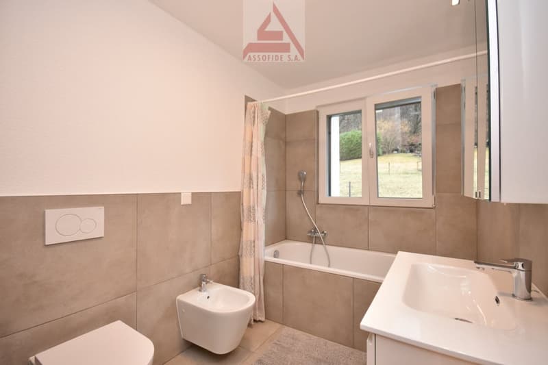 bathroom with modern fixtures, bathtub, separate shower, toilet, bidet, sink, beige tiles, and a large window with outdoor view