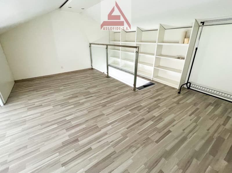 large room, wooden floor, white walls, large glass railing, tall white shelf
