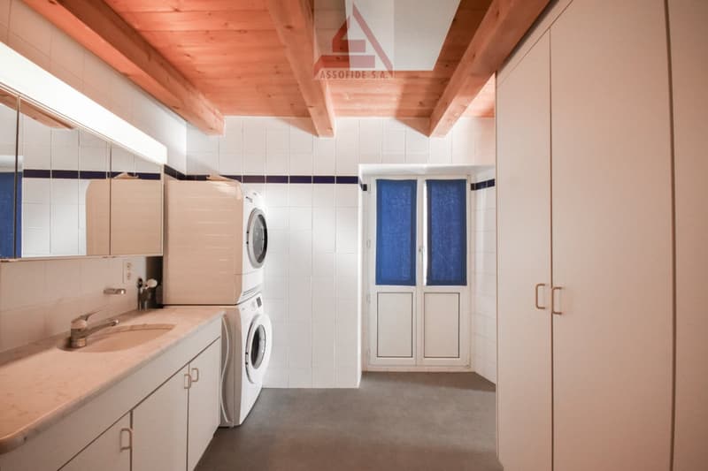 White cabinets, countertop, sink, and a washer dryer