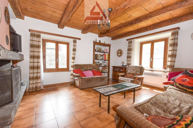 exposed wooden ceiling, Fireplace, tile floor, sofa, coffee table, television, bookshelf, chairs, bookshelves, window