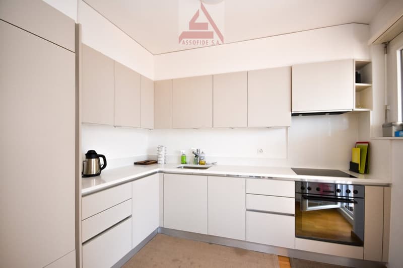 modern kitchen, white cabinets, countertop, sink, gas stove, oven, refrigerator