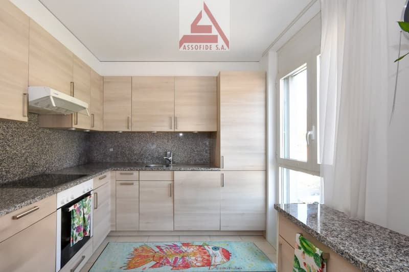 modern kitchen with wooden cabinets, granite countertops, integrated dishwasher, gas stove, sink, faucet, and a window