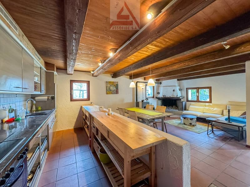kitchen with dining area, fireplace, living room with couch, dining table, chairs, wooden beams, tiled floor