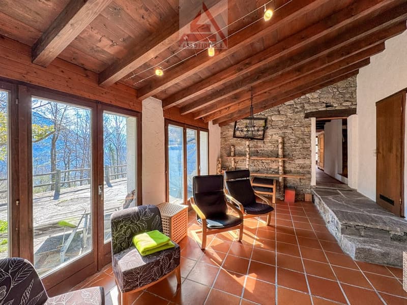 wooden ceiling, stone wall, large windows, chairs, table, fireplace, view of the outside
