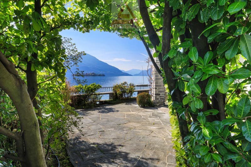 Stone paved walkway, lush greenery, lake view, stone pillar, stone bench