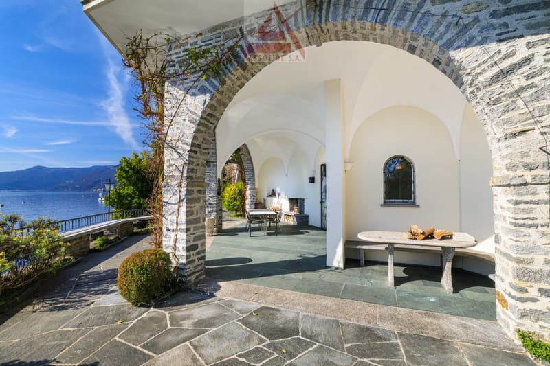 Stone exterior, arched entrance, outdoor seating, fireplace, lake view