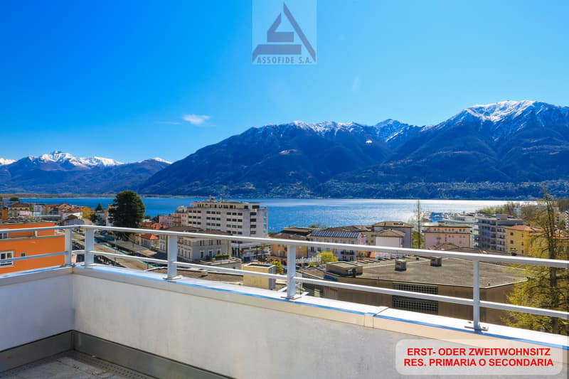 Building with balcony, overlooking mountains and lake