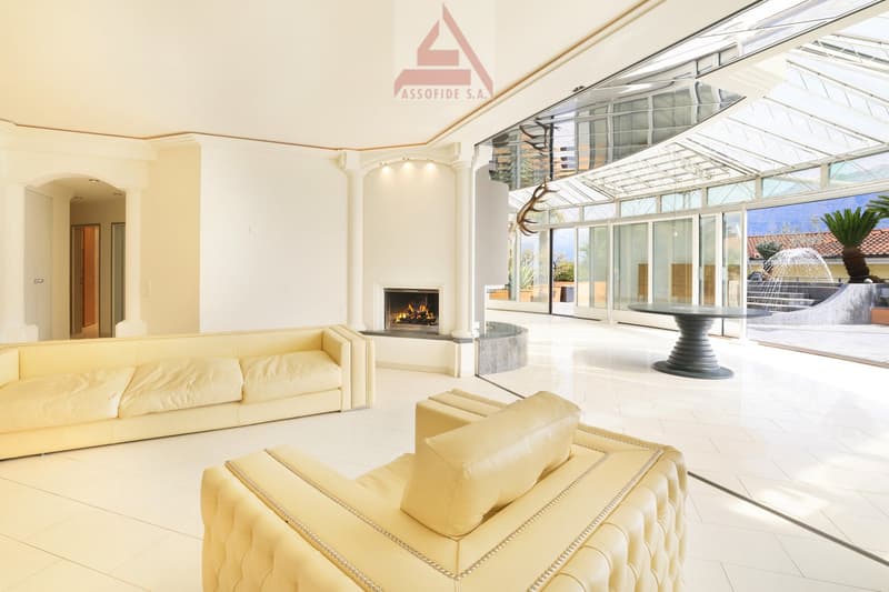 modern living room with fireplace, white tiles, glass walls, white couches, table, view