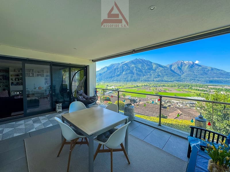 Balcony with table and chairs, glass doors, view of mountains and valley
