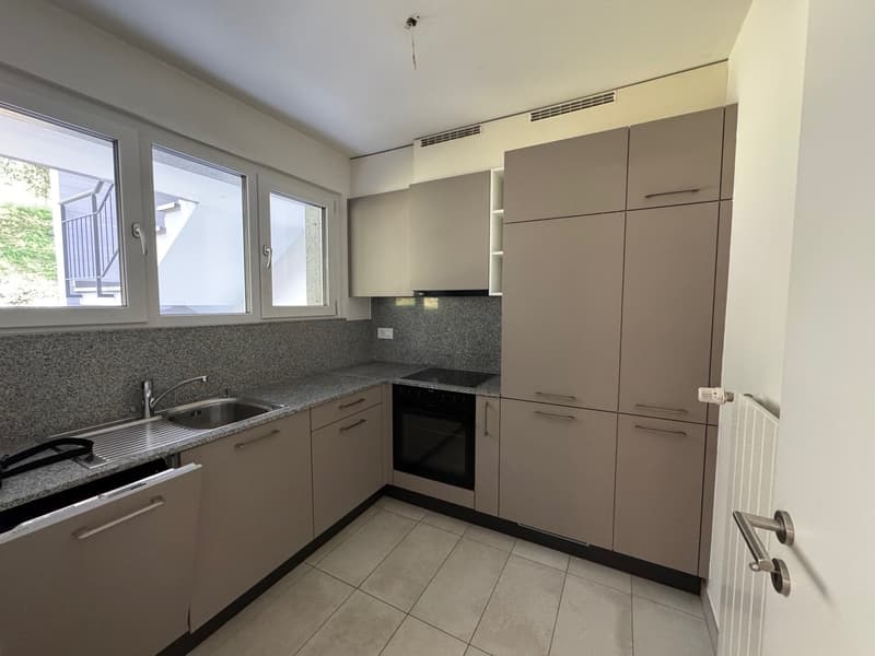 modern kitchen, neutral colors, undercounter oven, sink, granite countertop, tiled floor, double windows