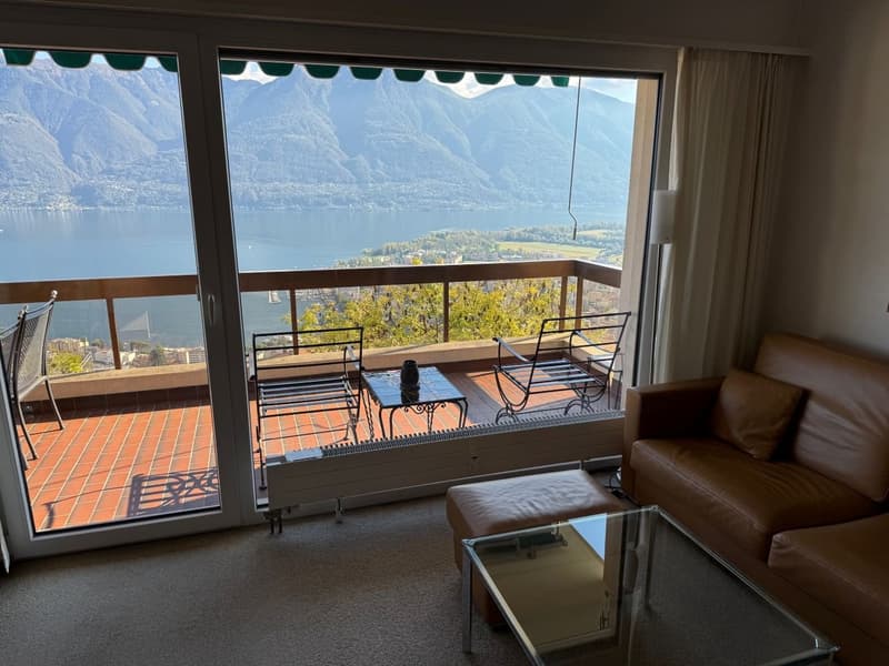 balcony, large glass door, couch, table, lake view