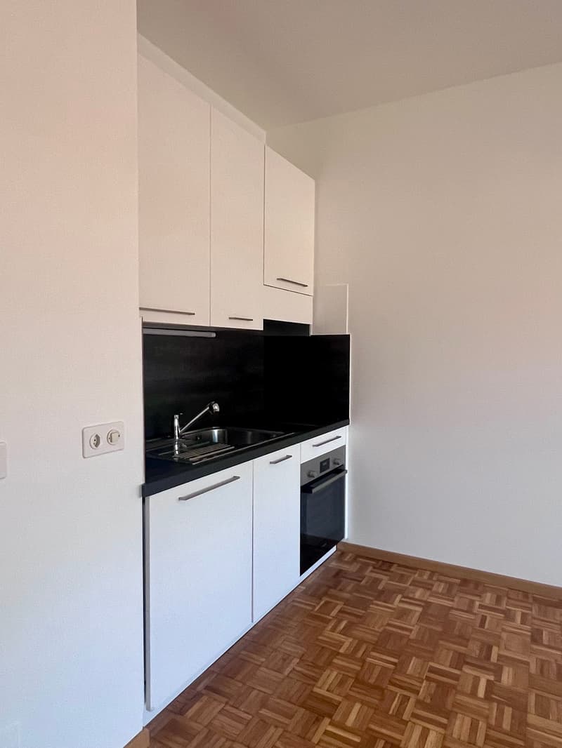 kitchen with white cabinets, black countertops, modern oven and sink