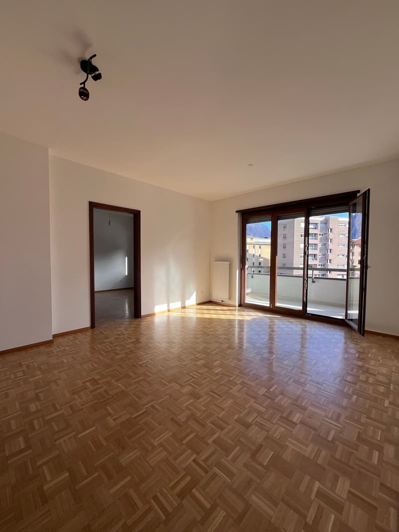 empty room, wooden floor, white walls, sliding glass doors, balcony, radiator