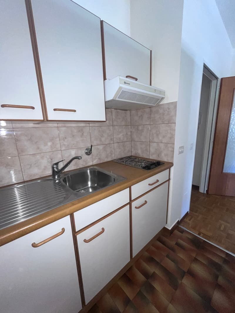 kitchen with white cabinets, wooden countertops, stainless steel sink, gas stove, wooden floor