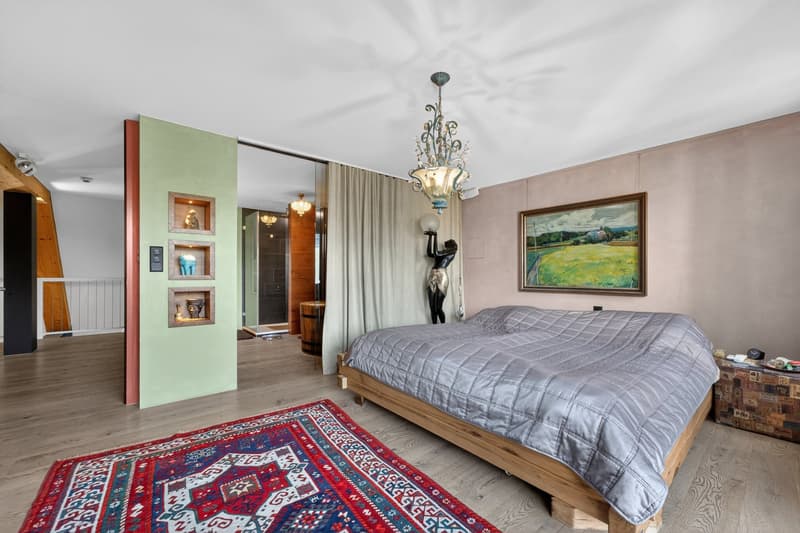 large bed, wooden floor, chandelier, rug, wall art, statue, curtains, wooden wall