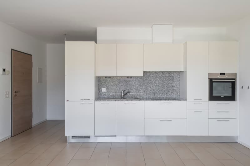modern kitchen with white cabinets, granite countertop, stainless steel sink, faucet, built-in oven, dishwasher, and washing machine
