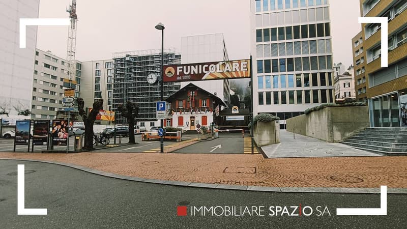 a commercial building with parking area in front