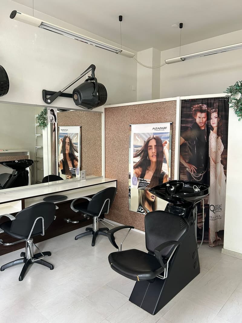 hair salon with 4 chairs, mirror, posters, sink