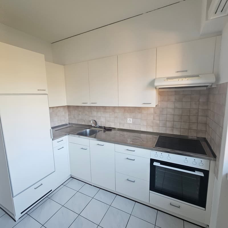 modern white kitchen, stainless steel countertops, tiled floor, integrated dishwasher, white cabinets, gas stove, extractor hood, built-in refrigerator, sink with faucet