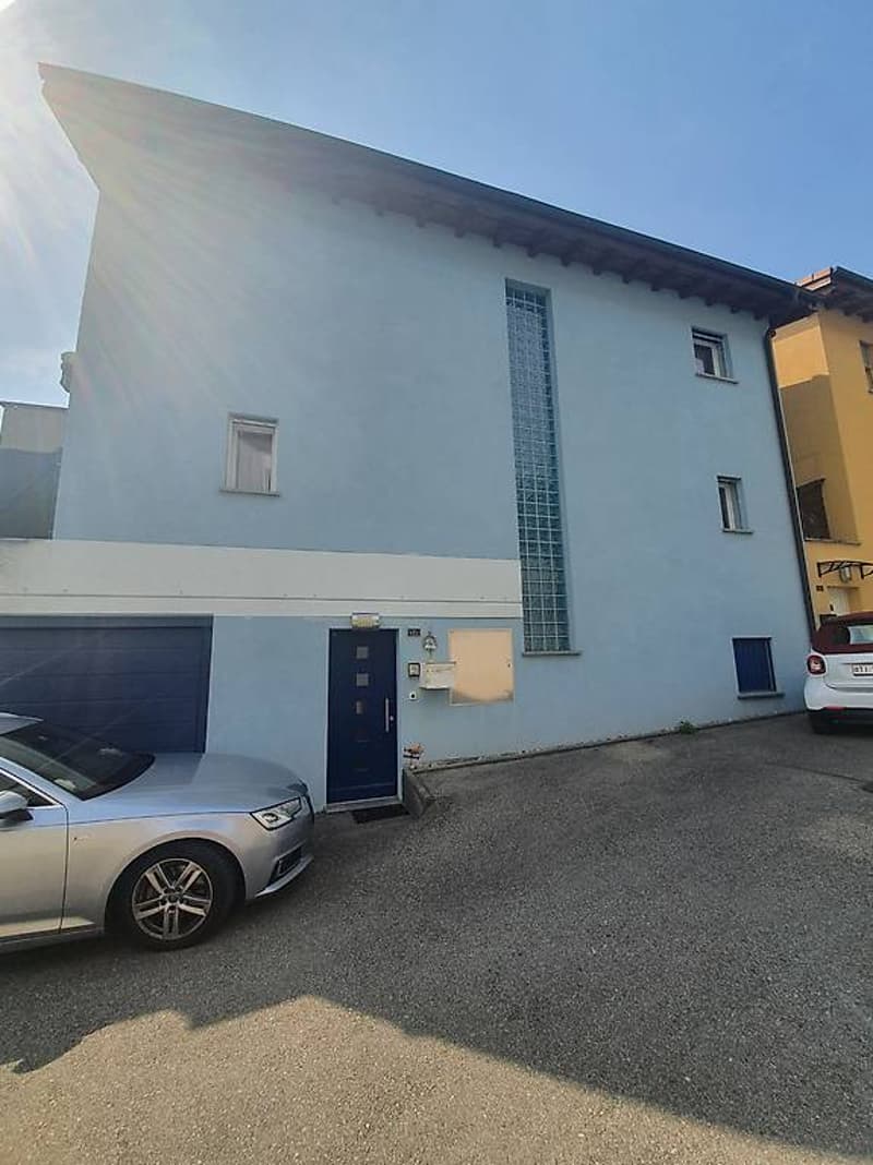 Two-story house, light blue exterior, garage, two cars parked in front