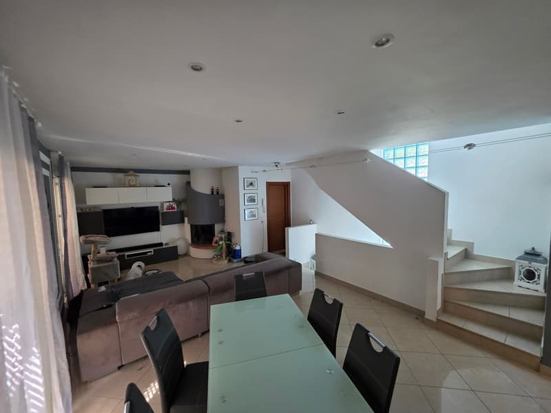 modern living room, fireplace, large windows, dining table, couch, television, shelves, stairs