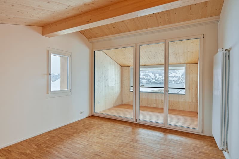 large windows, wooden flooring, sliding glass doors, balcony, natural light, minimal furniture