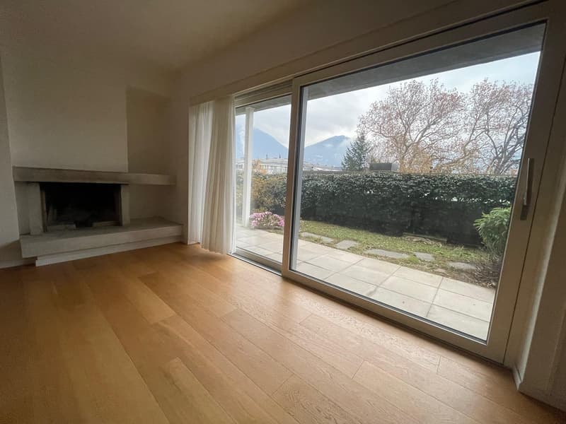 Fireplace, wooden floor, sliding glass door, view of a garden