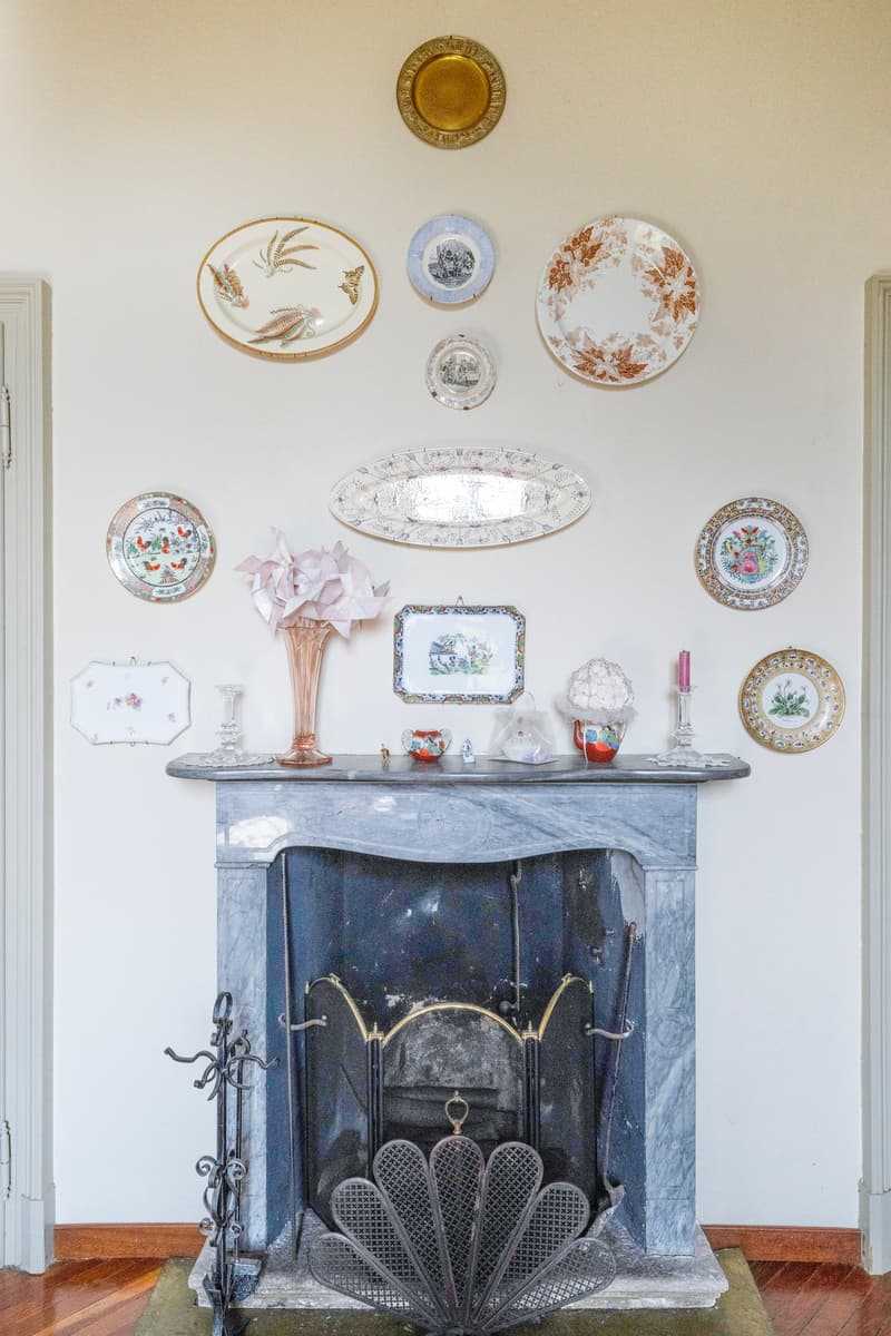 fireplace, decorated marble mantel, ornaments, plates on the wall