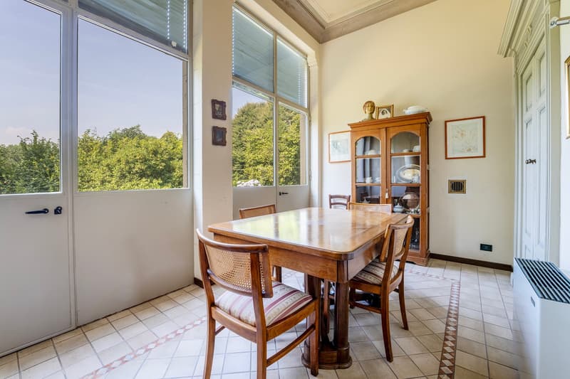 Dining table, chairs, sideboard, windows, tiled floor