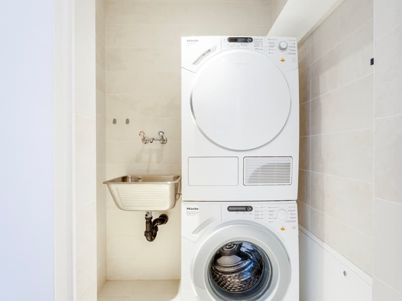 Laundry room with a sink, two Miele appliances: washing machine and dryer
