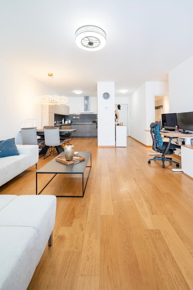 Wooden floor, open kitchen, dining table, chairs, couch, table, office desk, monitors, chair